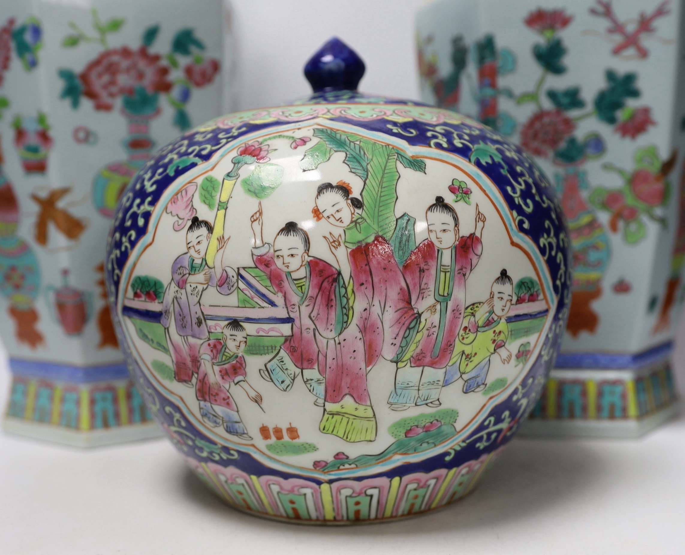 A pair of Chinese famille rose vases and a similar jar and cover, 38cm